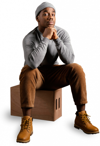 black men fashion model wearing a cap sitting and posing for photo